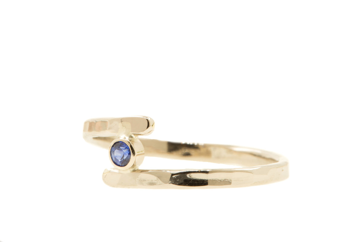 Handgemaakte en fairtrade fijne gehamerde witgouden ring met saffier.